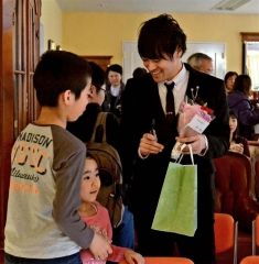 子供たちに花束をもらい、笑顔の三國さん