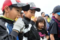 生のスイートコーンにかぶりつく子供たち