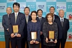 表彰を受けた中根さん、山口さん、楠田さん（前列左から）。後列は左から佐々木、石橋、宇野の各社長、石橋商工会長、金澤町長