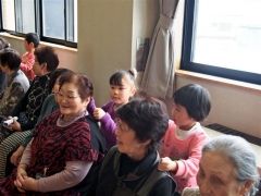 ほっとサロンのふれあい昼食会で高齢者たちに肩たたきをサービスする園児たち
