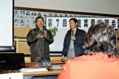 野菜の苗を見せながら、育て方をアドバイスする農家
