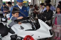 白バイにまたがり、笑顔を見せるちびっ子