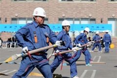 ノズルから放水する準備を訓練する消防団員たち