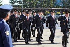 来賓に顔を向けて分団ごとに行進する団員たち