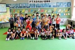 演奏後に熊谷さん（中列左）や中村さん（同右）らを囲んで記念撮影する児童たち
