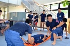 救急隊員から首の固定法を学ぶプール職員