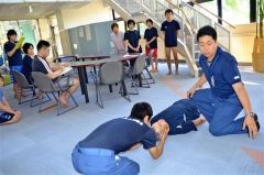 救急隊員から首の固定法を学ぶプール職員