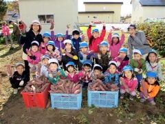 「たくさんとれたね」。収穫したサツマイモを前に喜ぶ園児たち