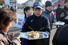 今年産で作ったピーナッツバターを塗ったパンを振る舞う農小の小学生たち
