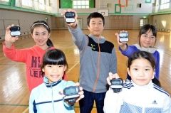 冬休みに貸与される万歩計と上札内小学校５、６年生児童