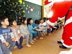 サンタクロースにプレゼントをもらって大喜びの子どもたち