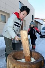屋外で餅つきする子ども