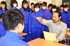 鉛筆で顔を測るデッサンの手法を由良さん（右）から学ぶ生徒