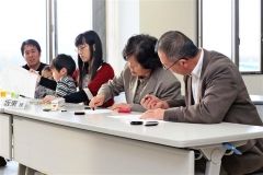 協定書に署名押印する家族