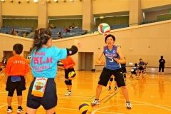 小学生と２つのボールを使ってパスする吉安選手