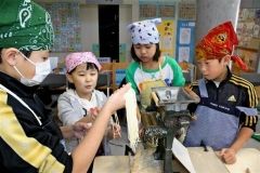 製麺機で麺を作る子どもたち