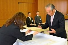 白井委員長（左）から当選証書を受け取る小野氏