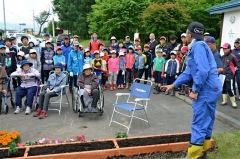 新田会長（手前）の説明を聞く子どもたち