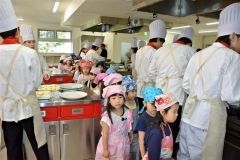 学生の調理姿を見学する園児たち