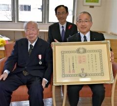 叙勲を受賞した（前列左）野津さんと勲記を持つ坂部副局長。齊藤副町長も見守った（後列）