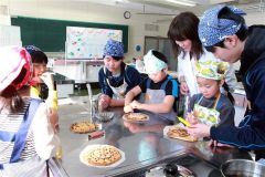 指導を受け、クッキーにチョコペンでデコレーションする子どもたち