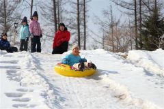 雪の滑り台で遊ぶ子供たち