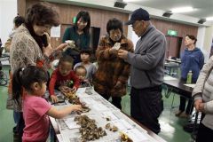 中田理事長（左）からキノコについて説明を受ける参加者