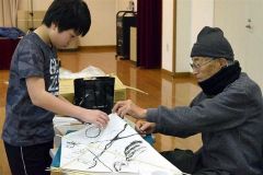 水野さん（右）にたこの作り方を教えてもらう参加児童