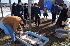 長谷代表（左）に革をなめす工程を案内してもらう池田高校の生徒ら