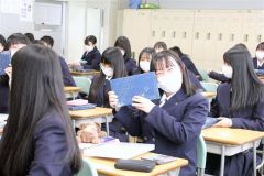 「白い恋人」を受け取り、笑顔の新入生