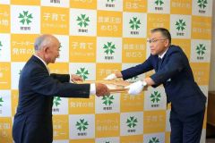 手島町長から勲記を受けとる宮西さん（左）