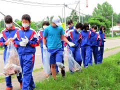 目を凝らし、道端のごみを拾い集める生徒