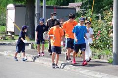 市街地区を歩いてごみを拾い集める児童と生徒ら