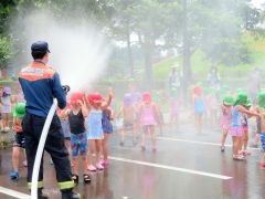 水槽車の水を浴びて楽しむ園児たち