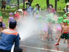 水槽車の水を浴びて楽しむ園児たち