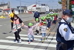 手を上げて横断歩道を渡る子どもたち（小山田竜士撮影）