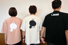 アイツがデザインされたオリジナルＴシャツを着る武藤会長（中央）ら