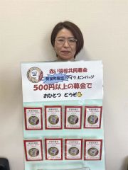 ピンバッジをＰＲする町社協職員