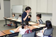 木村さん（中央）から読書感想文の書き方のコツを教えてもらう子どもら