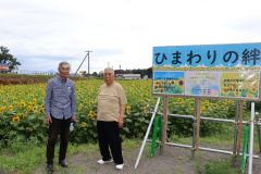 ヒマワリ畑の前に立つ大野さん（右）と鯛治さん（左）