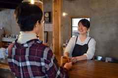 コーヒーを提供する美月店長（右）