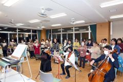 弦楽器に合わせて歌声を披露する団員
