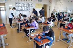 タブレットを操作して意見文を読み込む児童