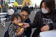 購入したあんパンを会場で食べる家族連れ（４日午前１１時半ごろ、須貝拓也撮影）