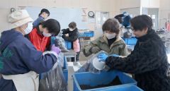 仕上げた培養土を袋詰めする受講者とサポートする生徒