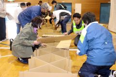段ボールベッドの組み立てを体験する参加者
