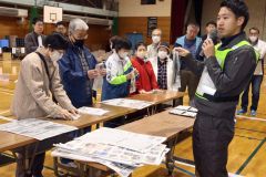 新聞紙スリッパを作る参加者