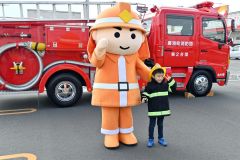 消防のキャラクターと写真を撮る子ども
