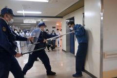 不審者を取り押さえる芽室交番の署員。約４０人の職員が見学した。