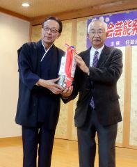 集まった入場料や募金を寄付する芳滝代表（左）と高橋会長